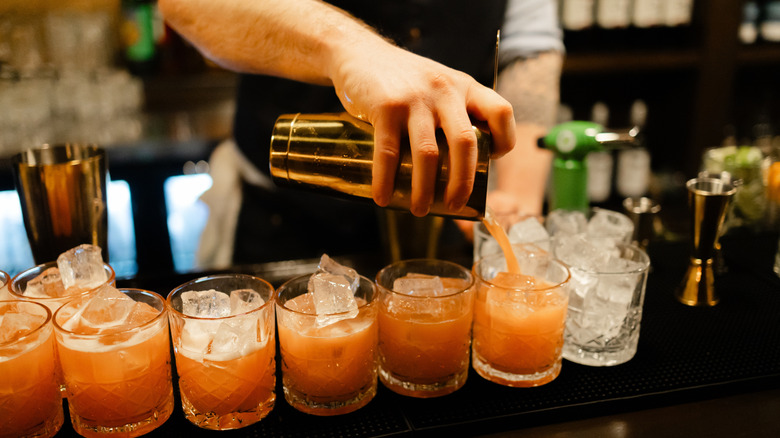 Bartender's hand pouring several cocktails
