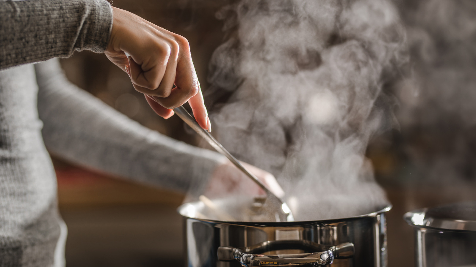 Home Cook Reheats Leftover Food With The Help Of Boiling Water On The Stove