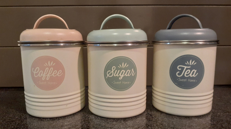 Vintage coffee, sugar, and tea canisters on granite countertop
