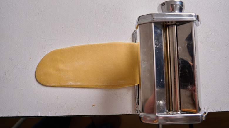 feeding the dough through a pasta machine