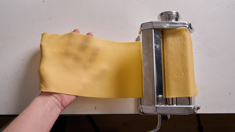 dough rolling through the machine into a hand
