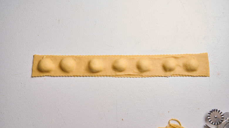 adhering the second strip of dough over the first