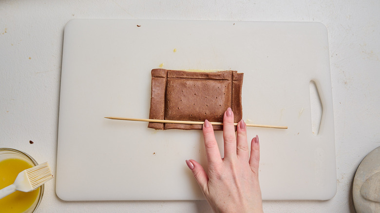 pressing down on edges of pop tart with a dowel