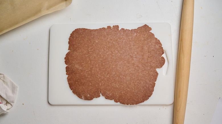 Dough rolled into a thin circle on a table