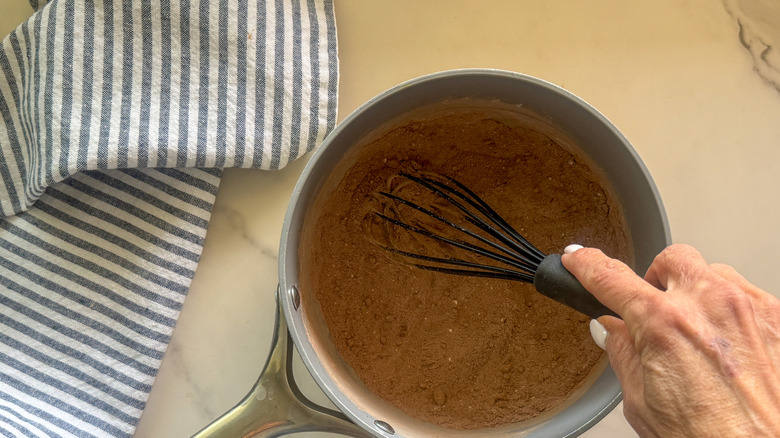 hand whisking mixture in pot