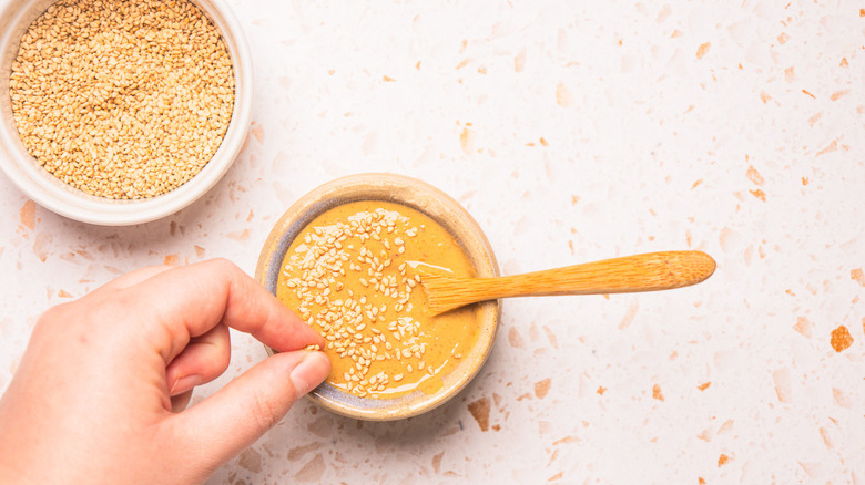 Topping sesame dressing with sesame seeds.