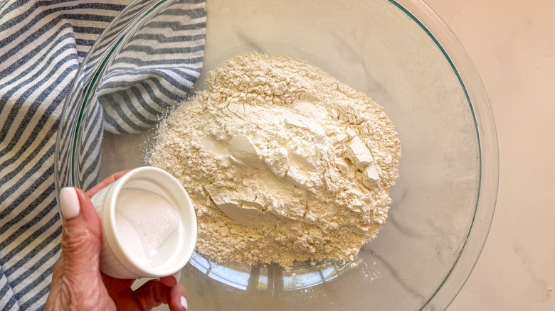 hand adding salt to bowl
