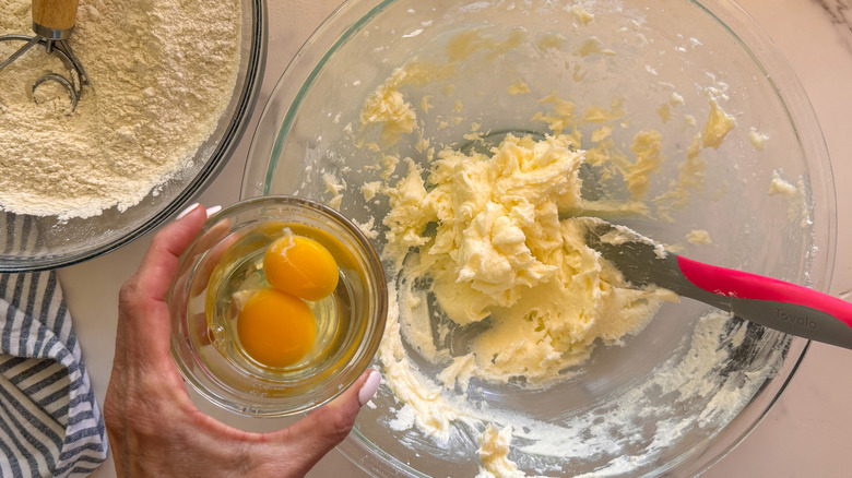 hand adding eggs to bowl