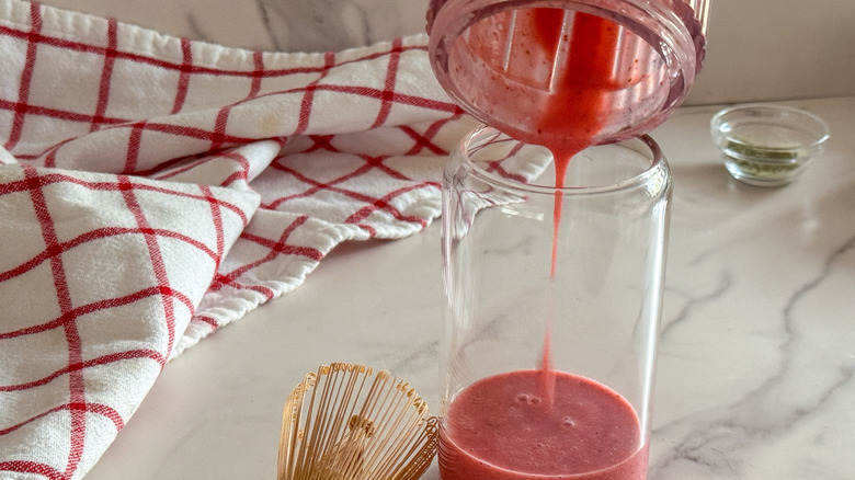 pouring strawberry puree into glass