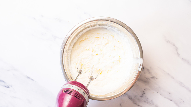 Whipped cream in bowl with mixer