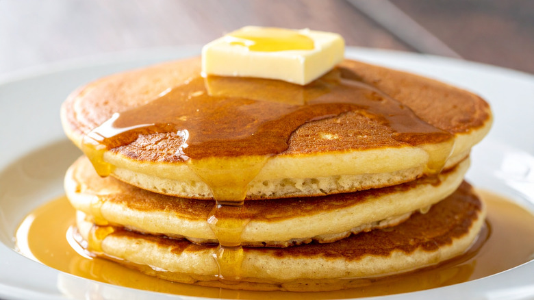 Stack of pancakes with pat of butter and syrup
