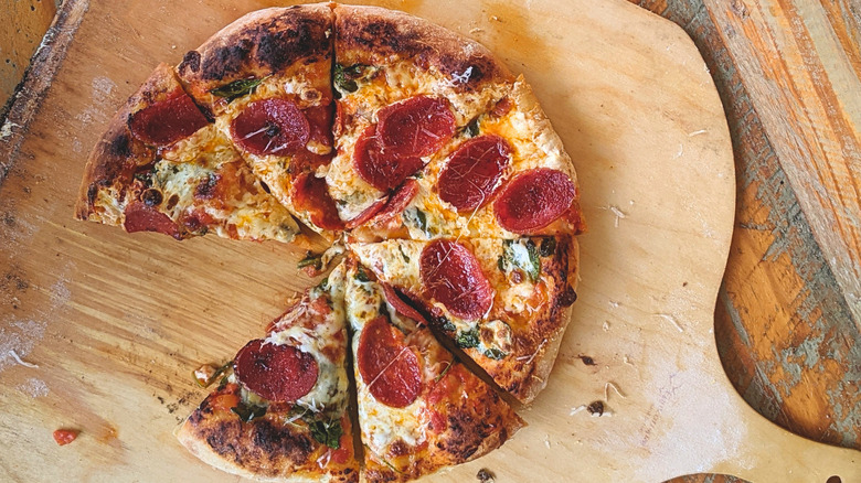 Baked pepperoni pizza with cheese pizza on peel