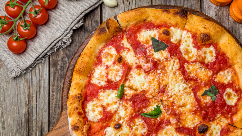 Baked pizza with cheese, broccoli, bubbly crust up close