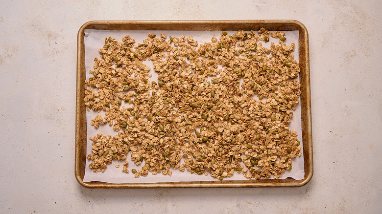 spreading oats onto baking sheet