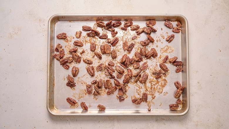 pecans coated with cinnamon sugar on baking sheet