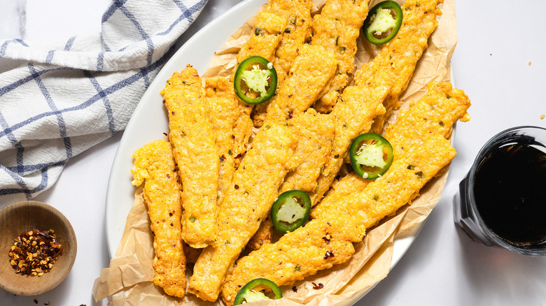 Baked spicy cheese straws on platter