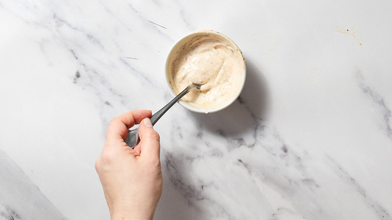 Mixing aioli in small bowl