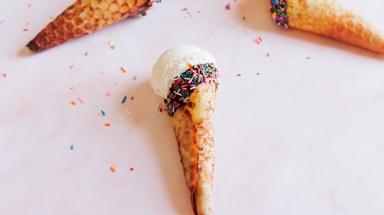 hand holding ice cream in waffle cone