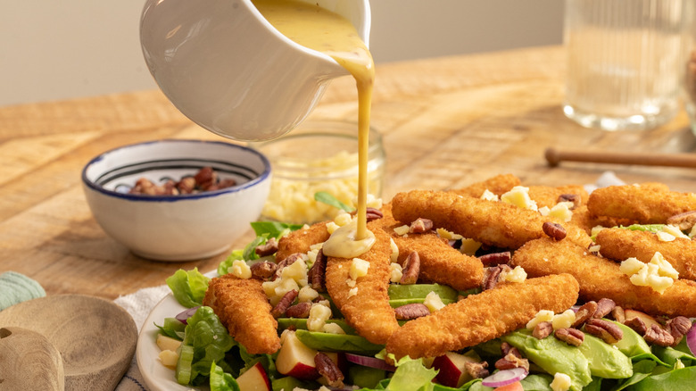 drizzling dressing onto salad
