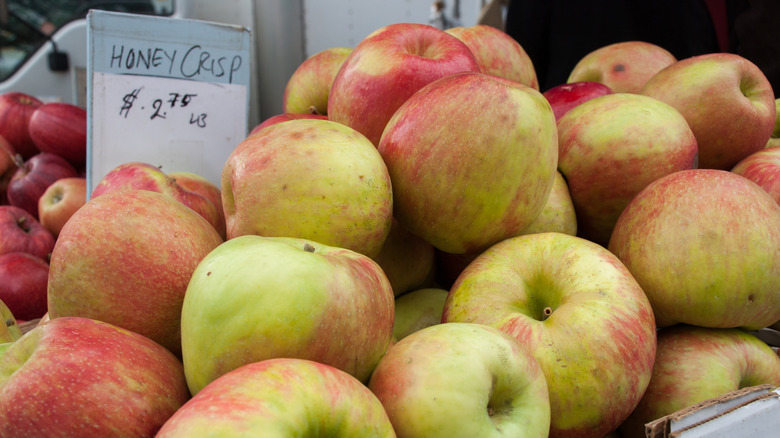 Honeycrisp apples for sale with sign in cardboard box.
