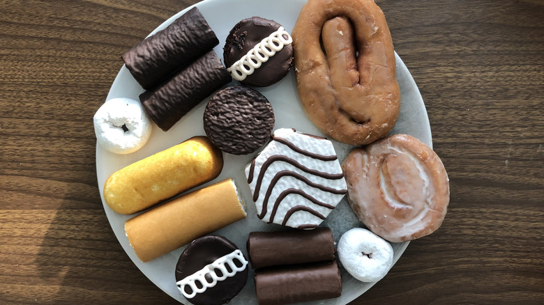 12 different Hostess and Little Debbie snacks all on a plate.