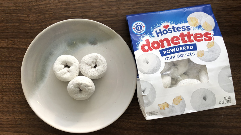 Three Hostess Powdered Donettes on a plate.