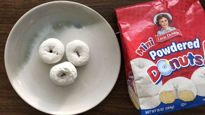 Three Little Debbie powdered donuts on a plate.
