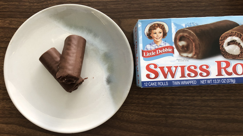 Two Little Debbie Swiss Rolls overlapping on a plate.