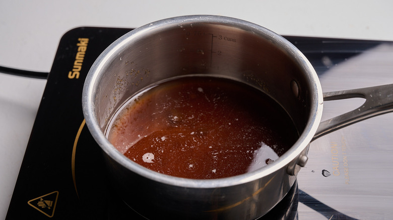 combining water and sugar in a saucepan