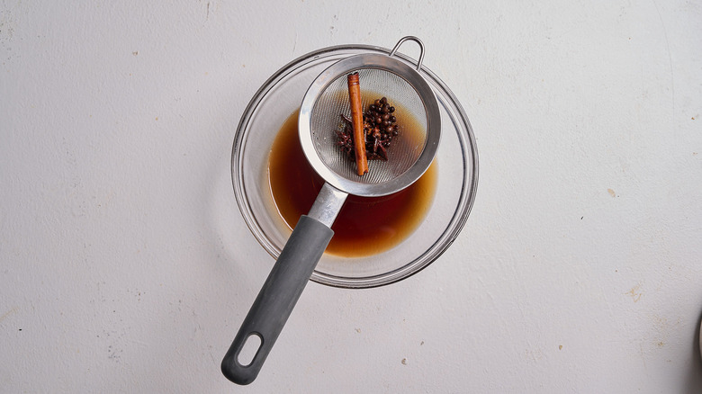 straining spices out of the syrup