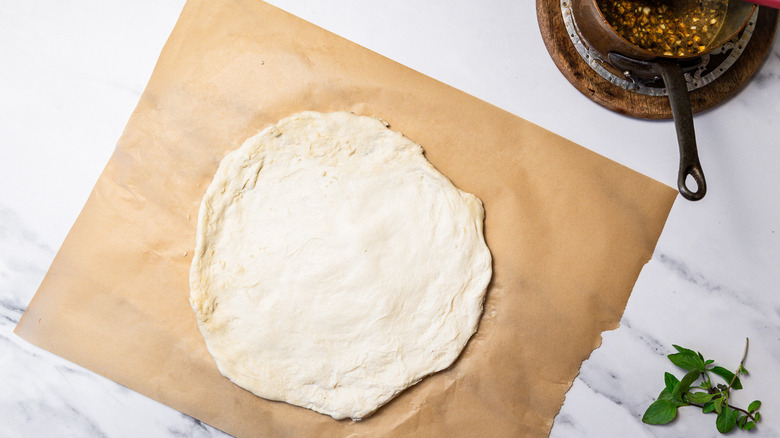 Dough spread out on parchment paper.