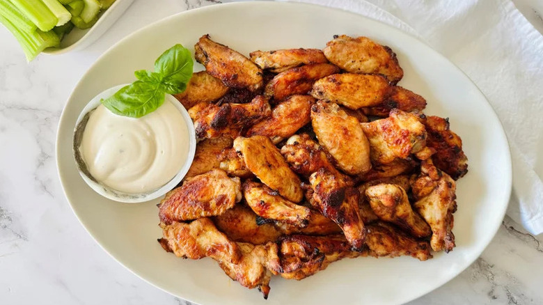 Copycat Wingstop Hot Honey Rubbed Wings on white plate with creamy sauce