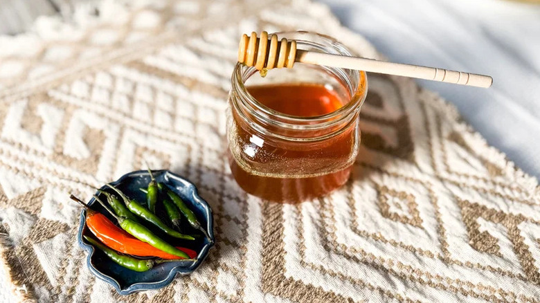 Homemade Hot Honey in small glass jar with chili peppers