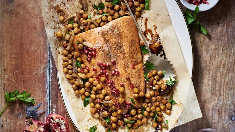 Hot Honey and Pomegranate-Glazed Salmon with chickpeas on parchment paper