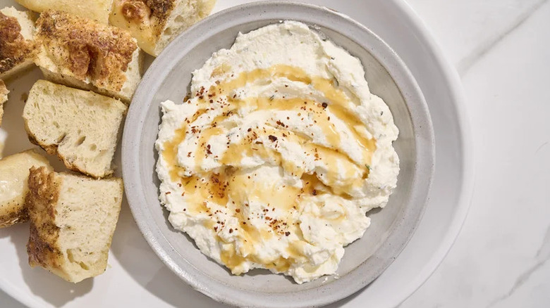 Hot Honey Cheese Dip in grey bowl with bread