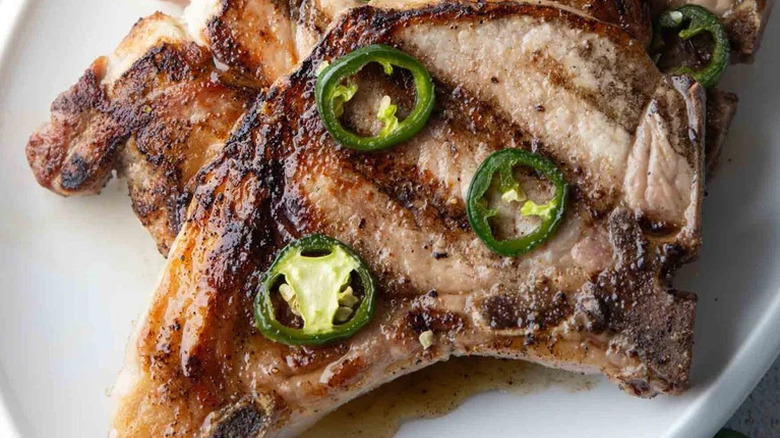 Hot Honey Pork Chops with sliced jalapenos on white plate