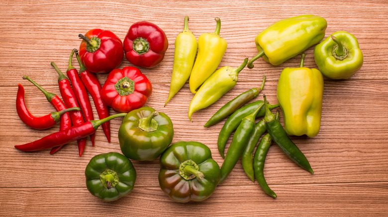 different hot pepper varieties on wooden table