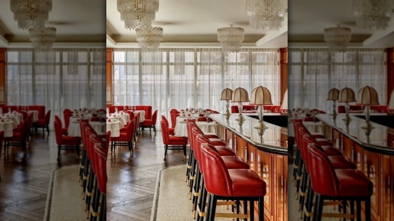 red high-top chairs at a bar with and square tables with white tablecloths