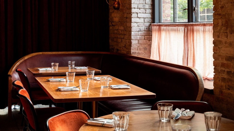 a red booth next to a window with a curtain