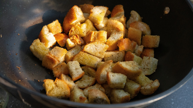 Close up of bread croutons frying in a pan
