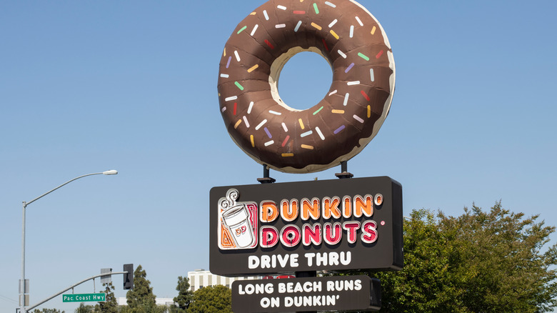 Dunkin' Donuts drive-thru sign against blue sky, the text reads 'long beach runs on dunkin''