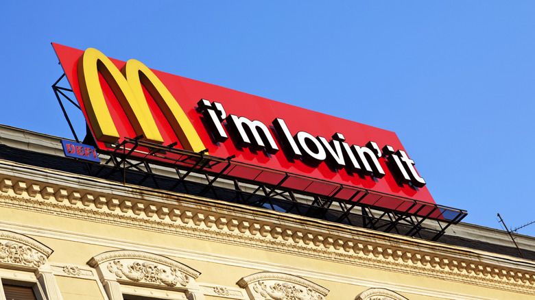 Exterior view of a McDonalds restaurant with McDonalds logo on the roof with the text "i'm lovin' it."