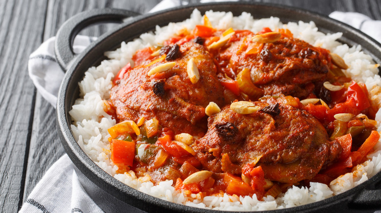 Country Captain stew and rice in cast iron pan on wood table