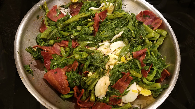 Poke salad in metal bowl black background