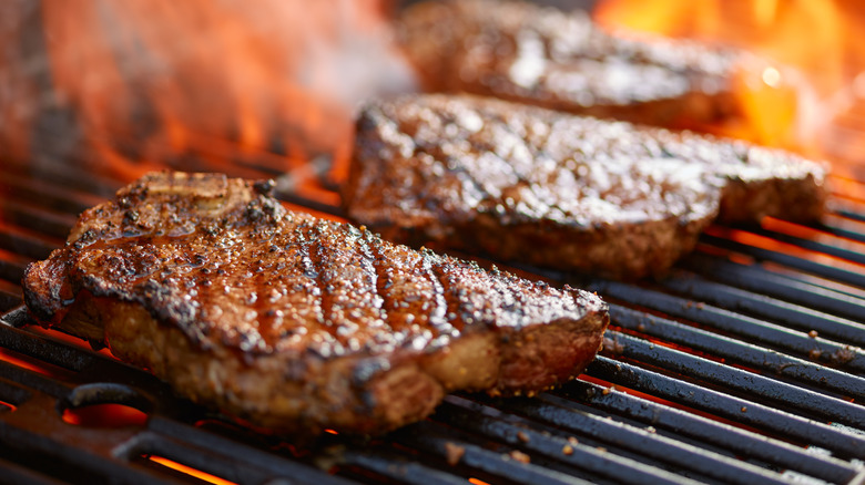 Steaks grilling on open flame