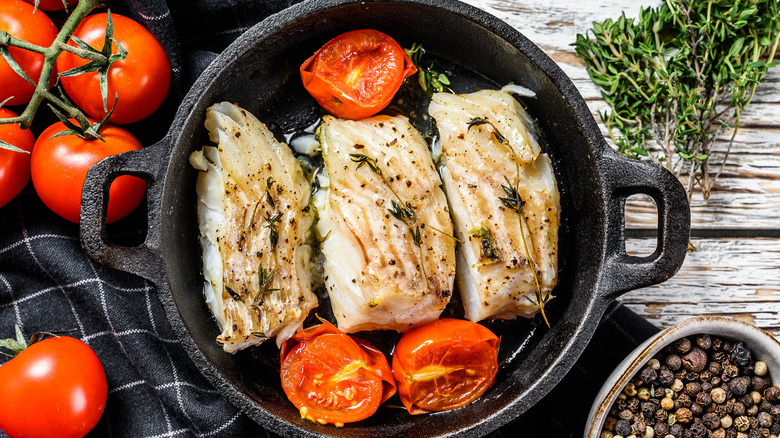 Fish and tomatoes in a cast iron pan