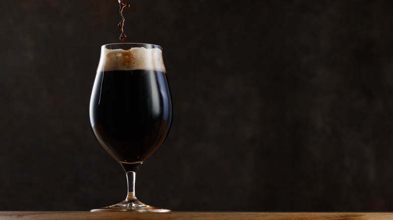 dark beer pouring into glass