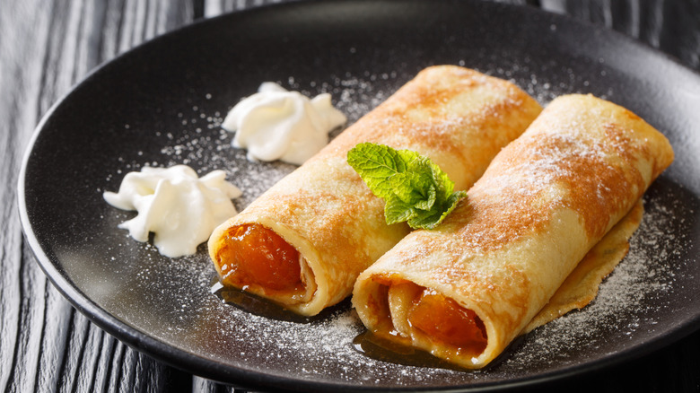 Closeup of Austrian crepes on a plate with whipped cream and powdered sugar