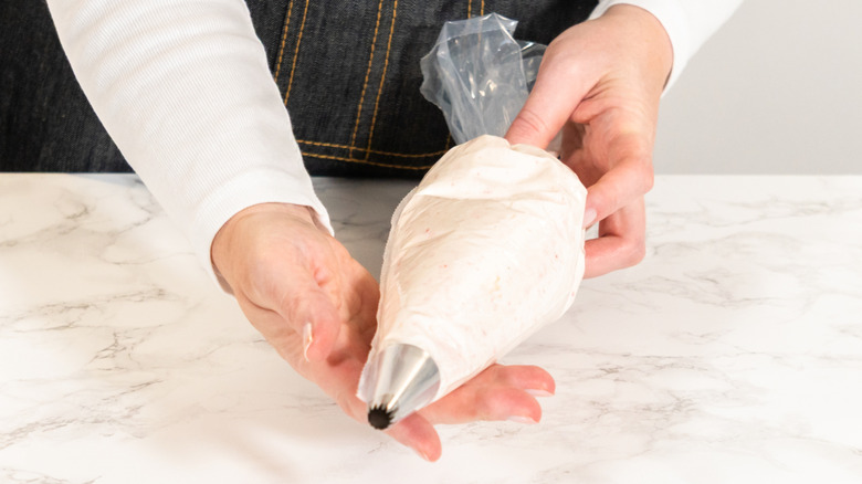 Person holding a filled piping bag