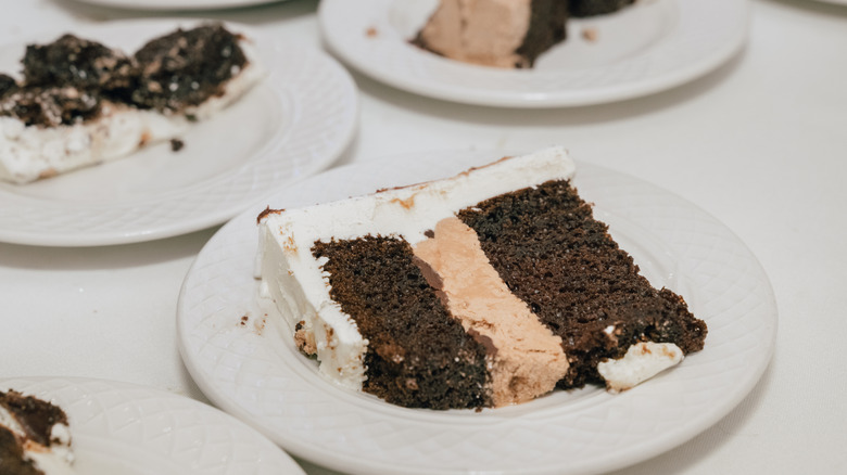 A thin slice of chocolate and vanilla sheet cake on a white plate